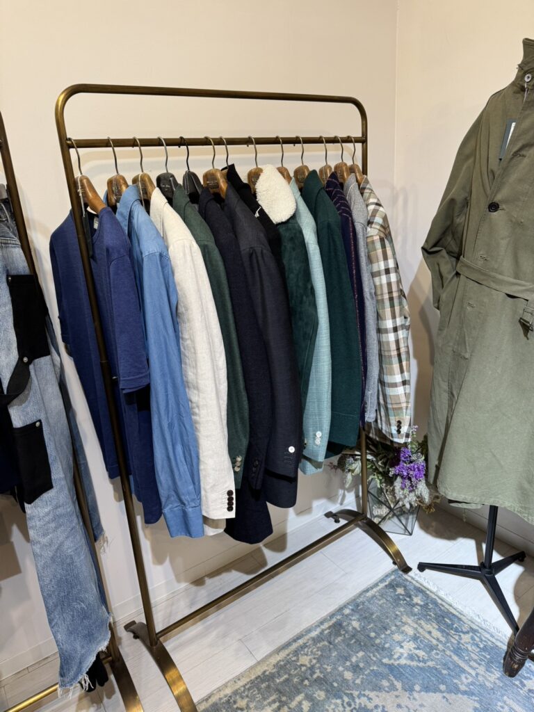 会場全体の写真：サルト銀座本店の洗練された店内に、色とりどりのジャケットやコート、ラックが並んでいる様子
