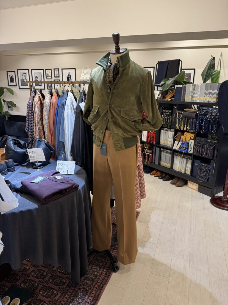 会場全体の写真：サルト銀座本店の洗練された店内に、色とりどりのジャケットやコート、ラックが並んでいる様子