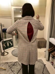 アクションプリーツの手法でお直ししたコートを着て動いてみることで着やすさを表現した画像