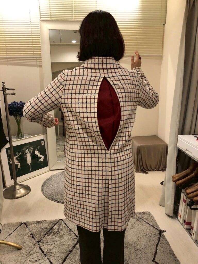 アクションプリーツの手法でお直ししたコートを着て動いてみることで着やすさを表現した画像